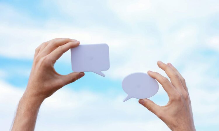 Two hands holding text bubbles.